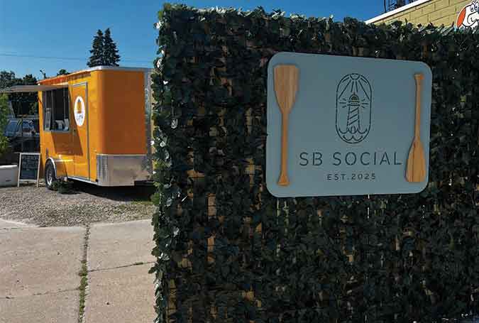 sign on a fence with food truck